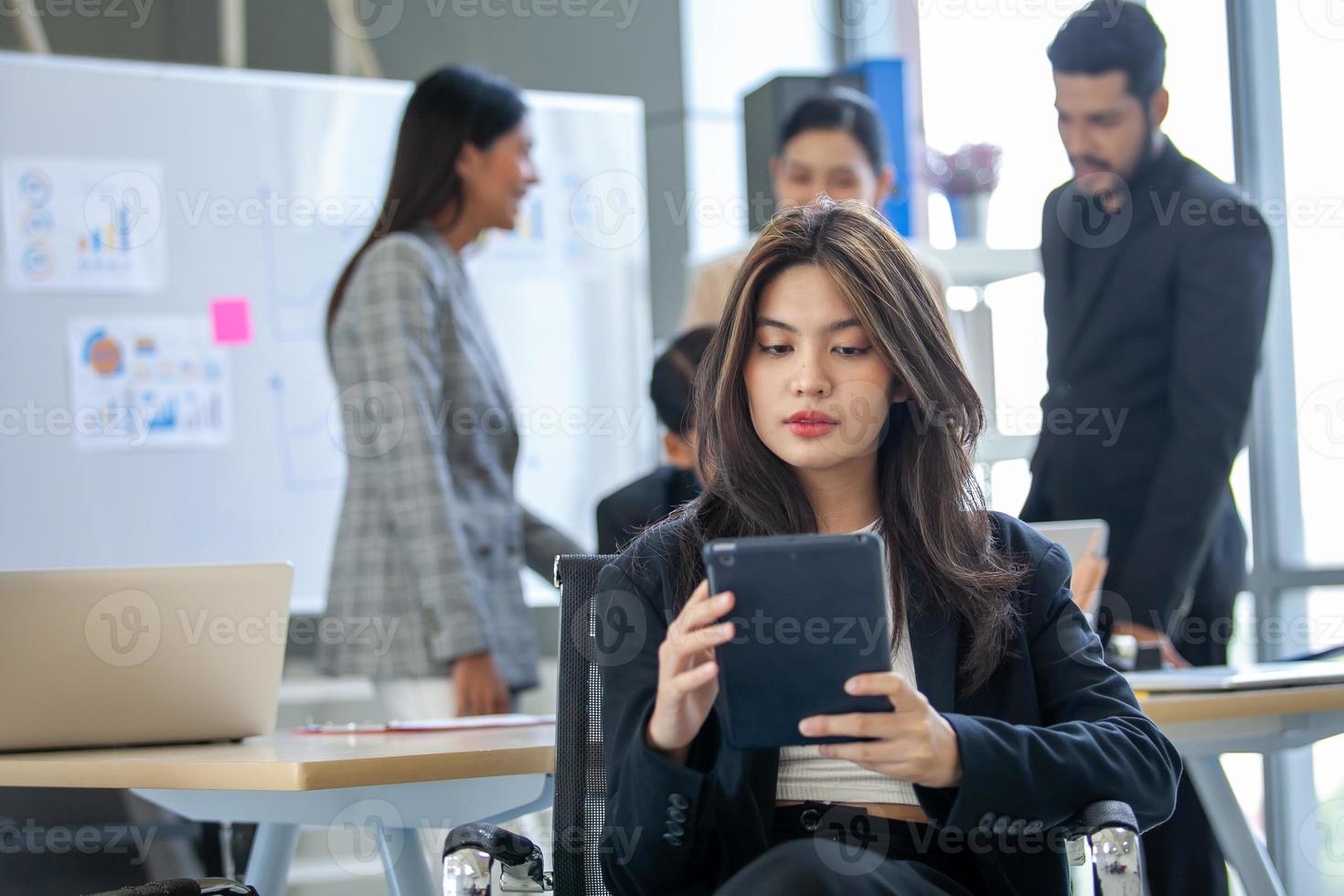 portrait d'une belle femme d'affaires asiatique travaillant au bureau, belle femme utilisant un pavé tactile avec le sourire sur le lieu de travail. photo