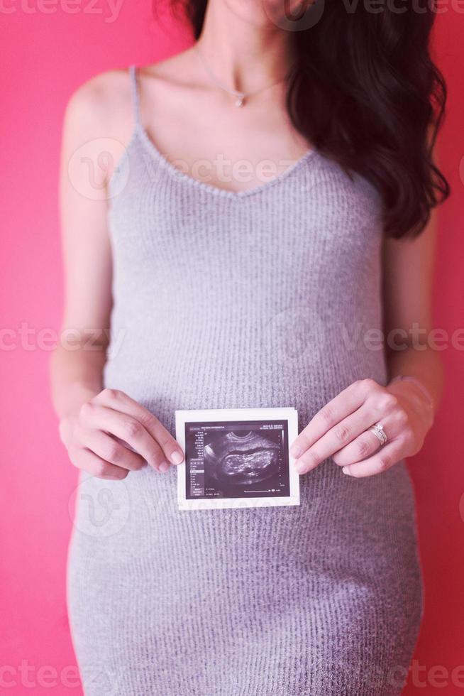 femme enceinte heureuse montrant une image échographique photo