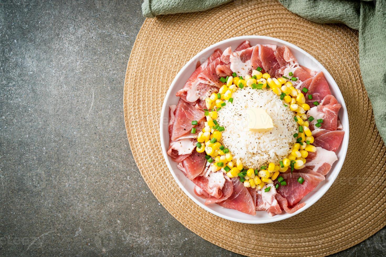 porc frais cru tranché avec du riz et du maïs sur une assiette et prêt à cuire photo