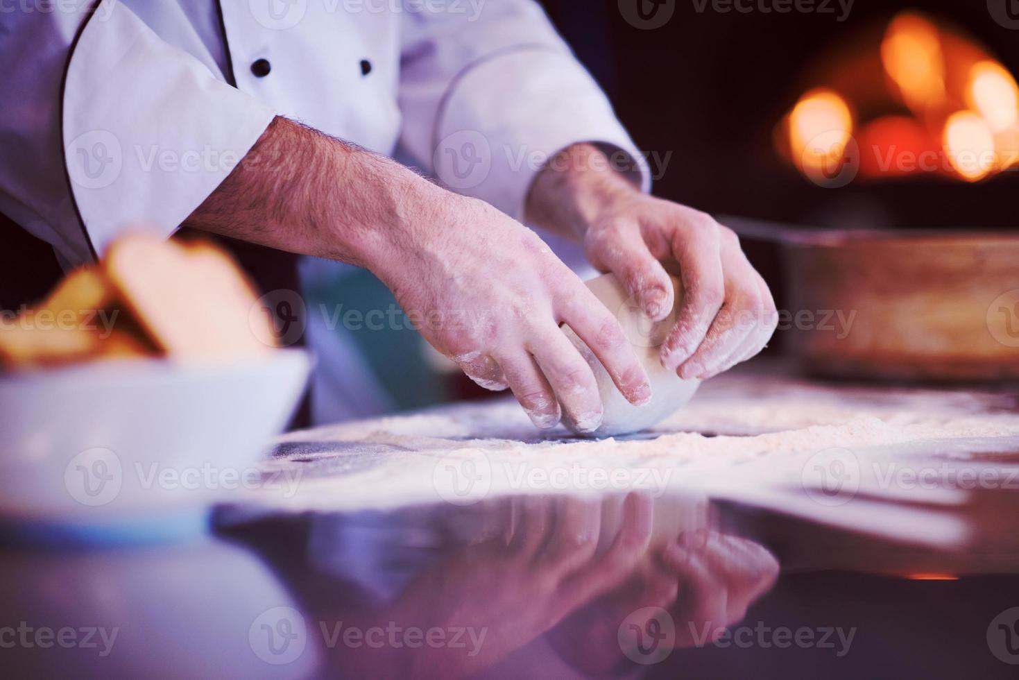 mains de chef préparant la pâte pour la pizza photo