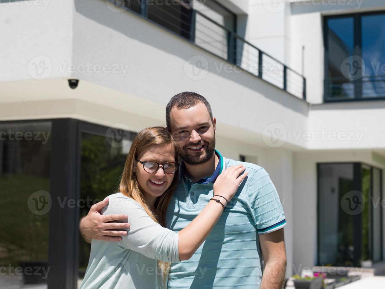 couple s'embrassant devant une nouvelle maison de luxe photo