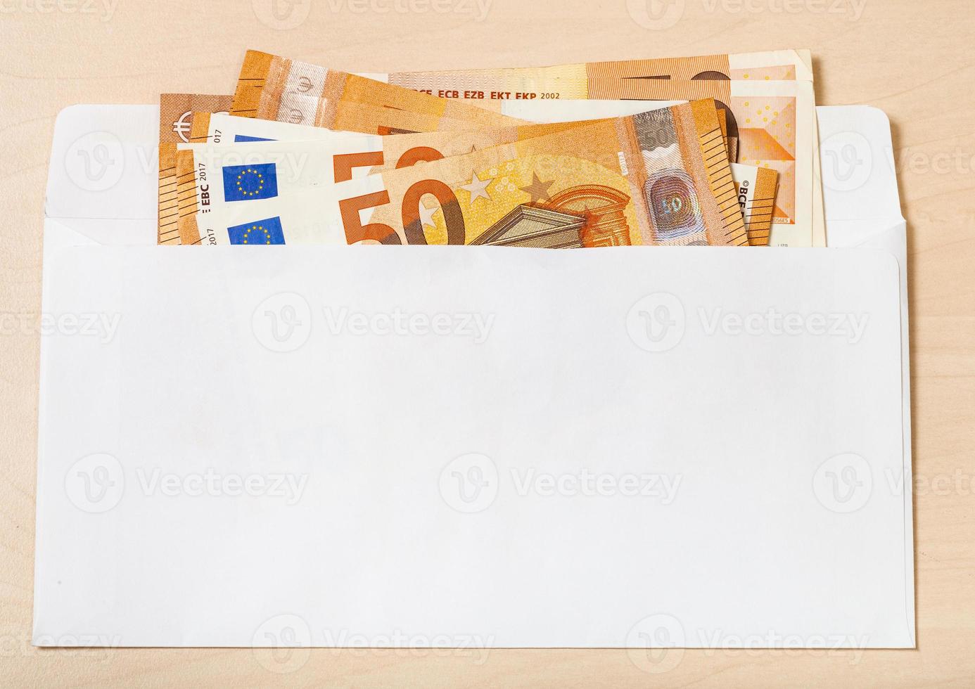 Plusieurs billets de cinquante euros dans une enveloppe sur la table photo