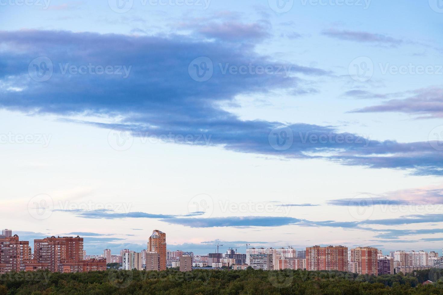 ciel bleu avec des nuages sombres sur la ville au crépuscule de l'été photo