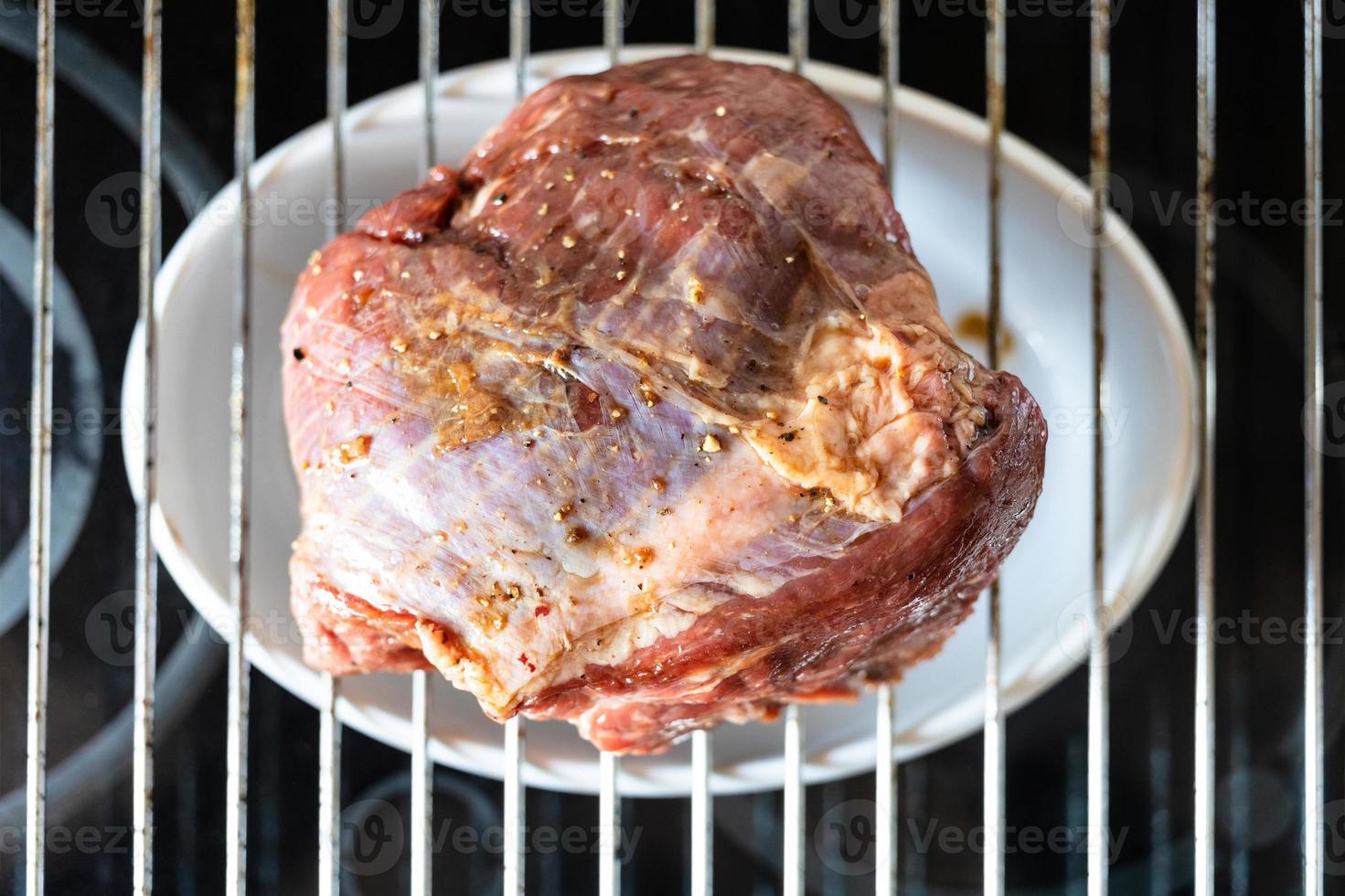 morceau de boeuf mariné sur la grille du gril photo