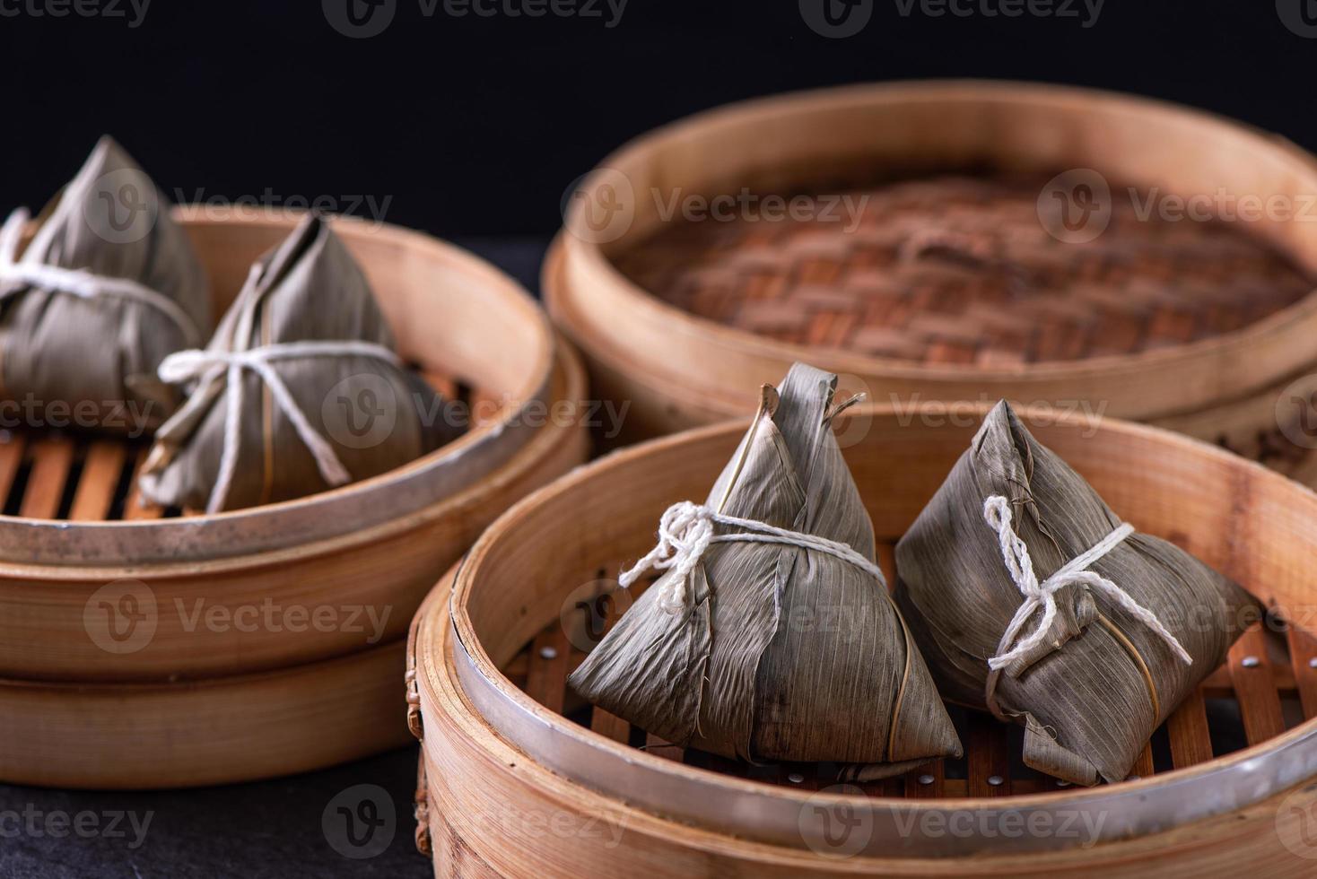 boulette de riz zongzi manger - jeune femme asiatique mange de la nourriture traditionnelle chinoise sur une table en bois à la maison pour la célébration du festival du bateau-dragon, gros plan photo