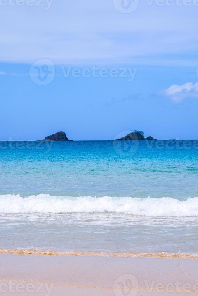 belle plage de sable de couleur or étonnante avec des vagues douces isolées avec un ciel bleu ensoleillé. concept d'idée de tourisme tropical calme, espace de copie, gros plan photo