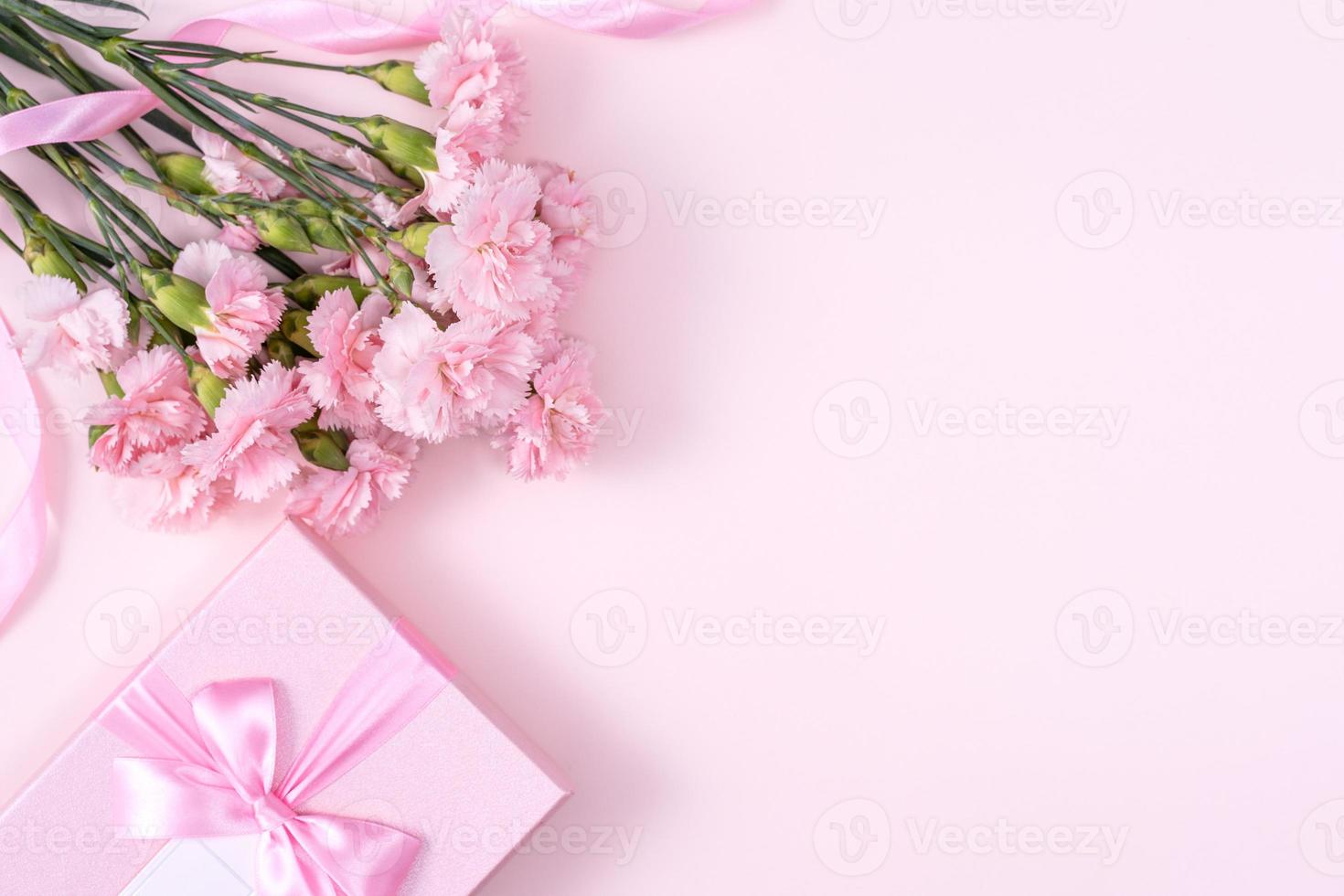 fête des mères, concept de design d'arrière-plan de la saint-valentin, beau bouquet de fleurs d'oeillets roses sur une table rose pastel, vue de dessus, mise à plat, espace de copie. photo