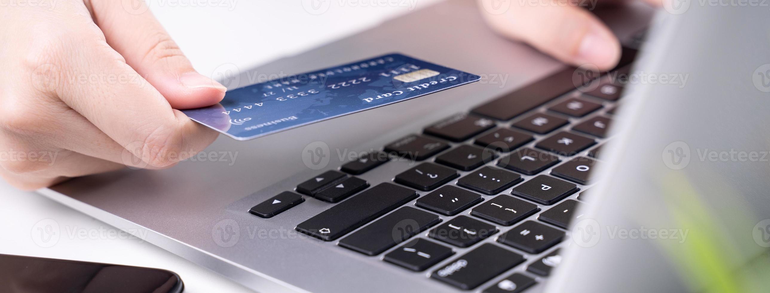 paiement en ligne de bureau, achats à domicile, paiement électronique avec concept de carte de crédit, ordinateur portable sur fond de tableau blanc avec panier, gros plan. photo