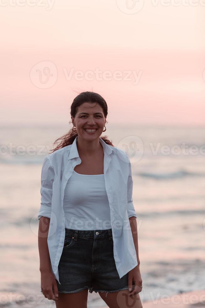 heureuse femme insouciante profitant du beau coucher de soleil sur la plage. mise au point sélective photo