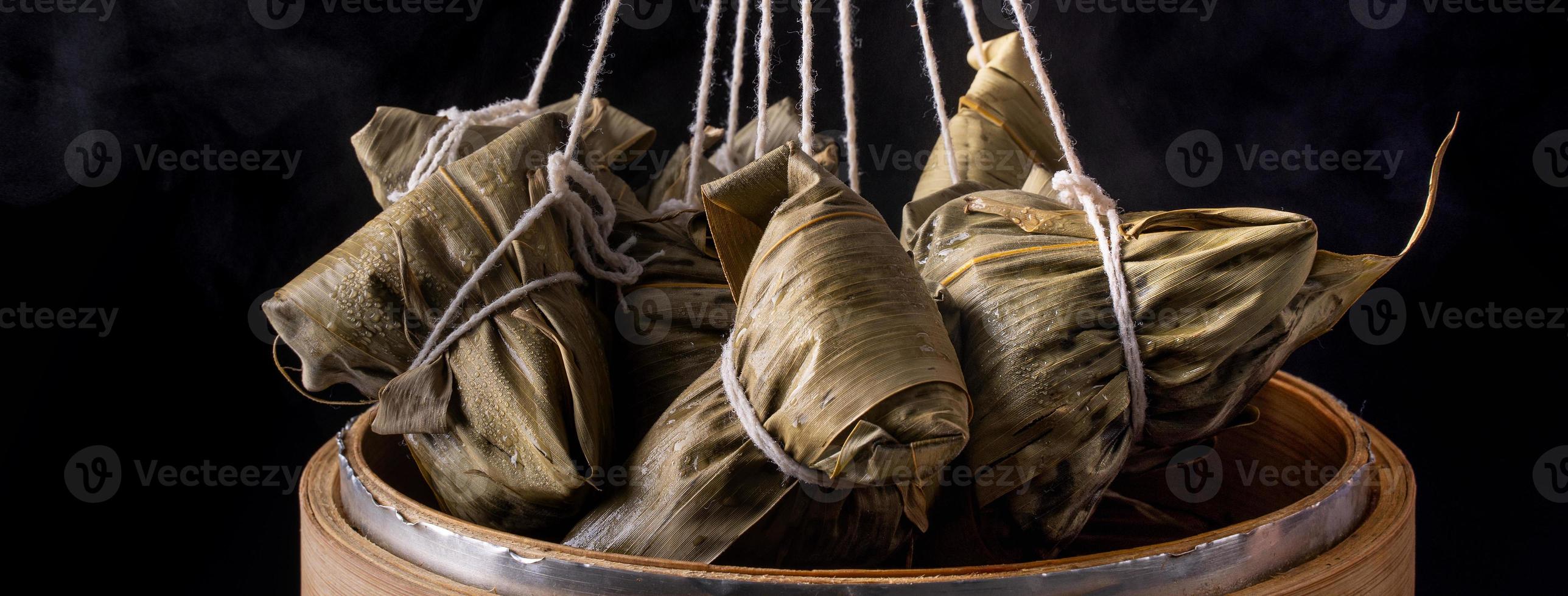 boulette de riz, zongzi - tas de plats cuisinés traditionnels chinois sur une table en bois sur fond noir, concept de festival de bateaux-dragons, gros plan, espace de copie photo