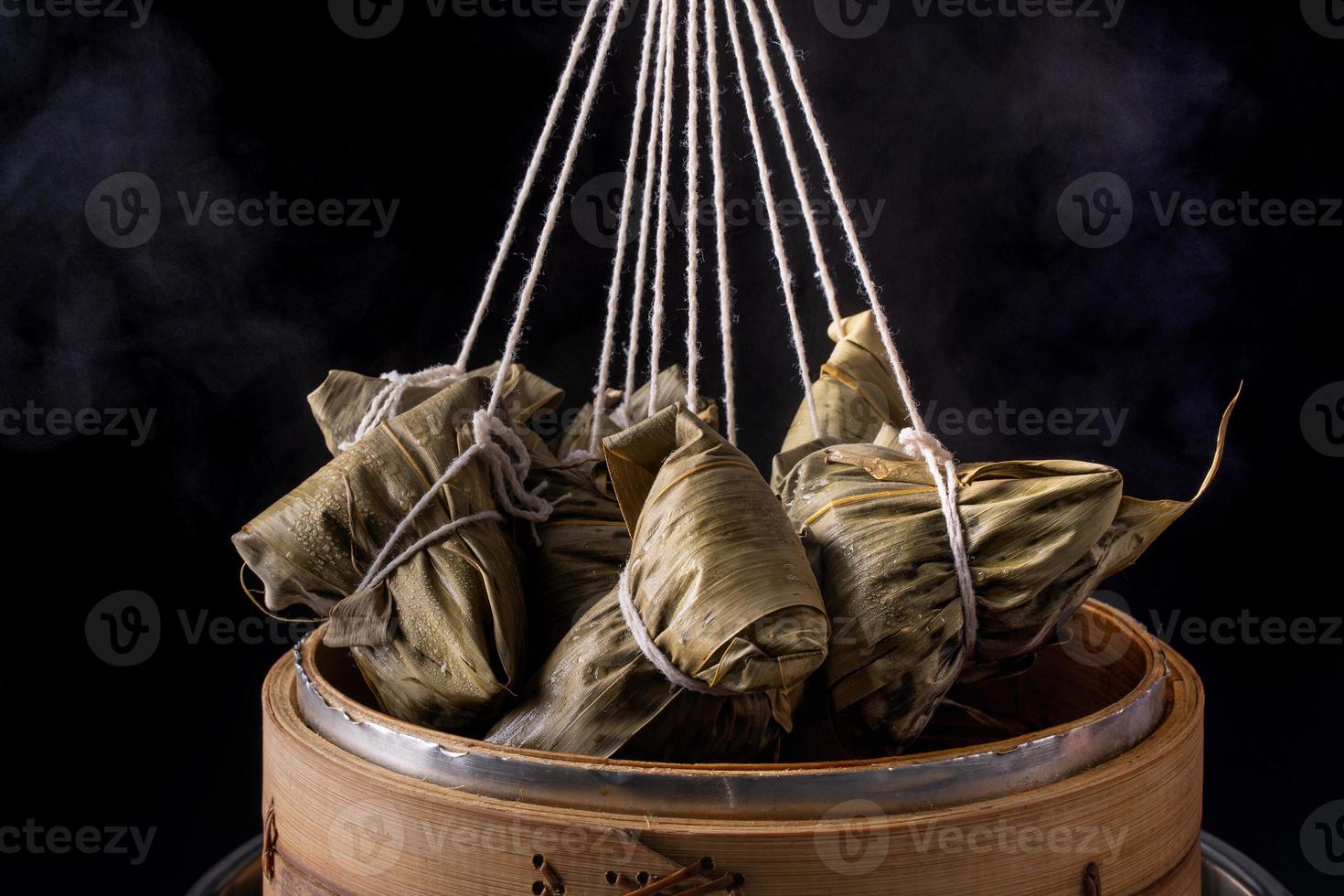 boulette de riz, zongzi - festival des bateaux-dragons, tas de plats cuisinés traditionnels chinois dans un bateau à vapeur sur une table en bois sur fond noir, gros plan, espace pour copie photo