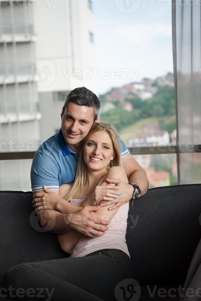jeune beau couple étreignant sur le canapé photo