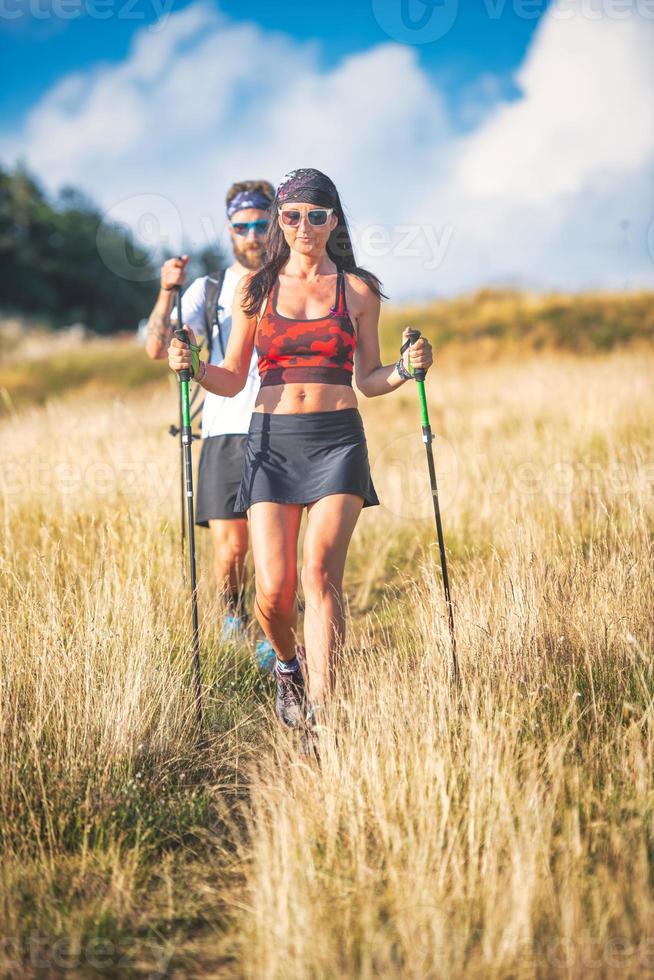 jeune couple lors d'une randonnée de marche nordique photo