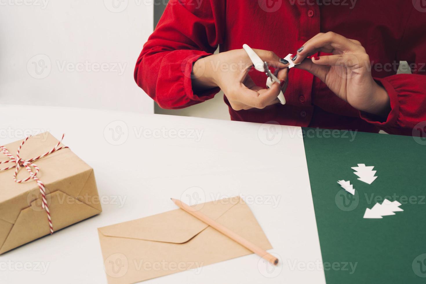 femme pliant l'arbre de noel avec boîte-cadeau et enveloppement. photo