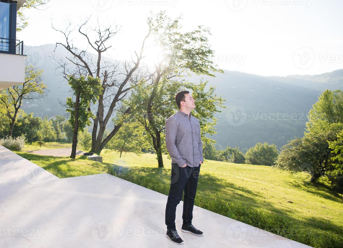 homme devant sa villa de luxe photo