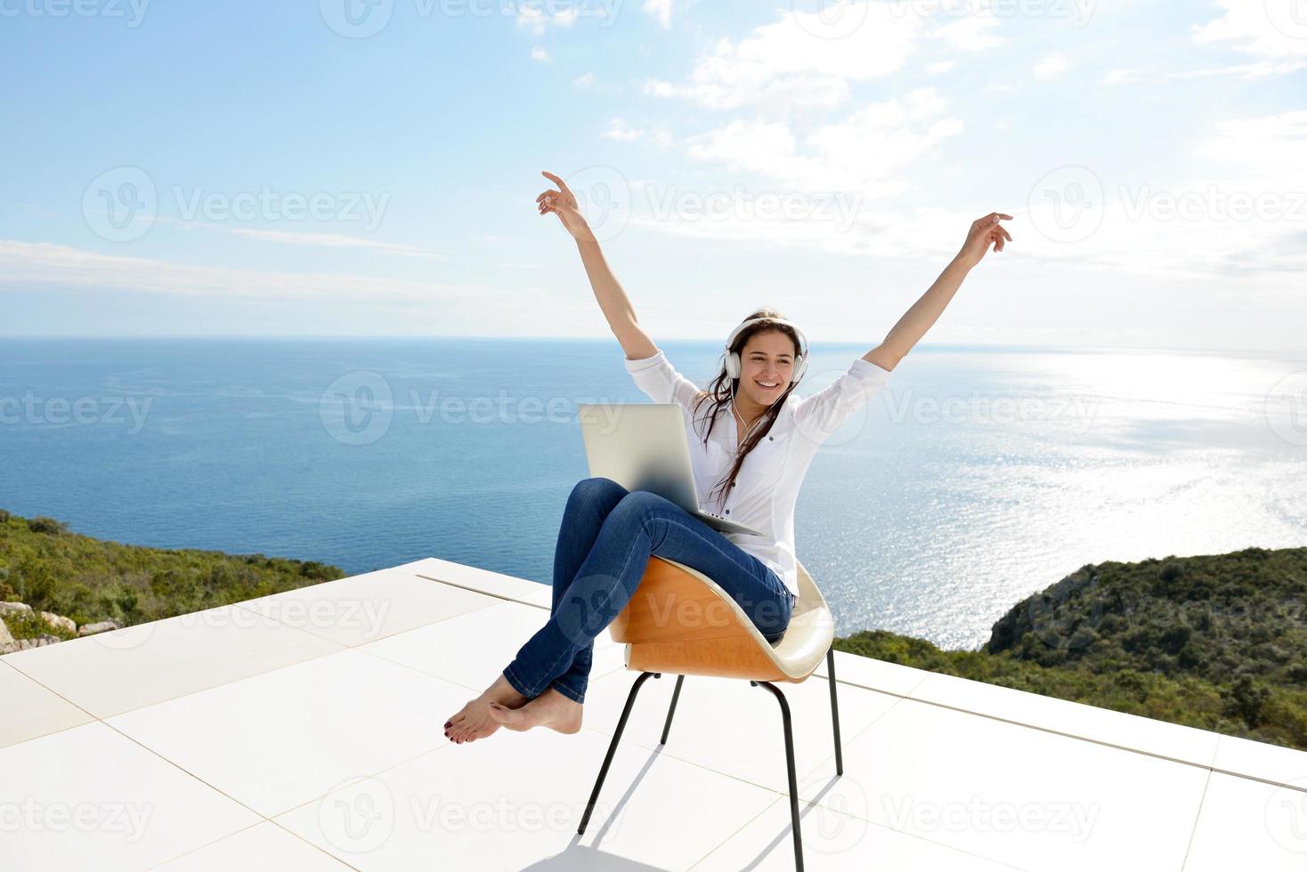 jeune femme détendue à la maison travaillant sur un ordinateur portable photo