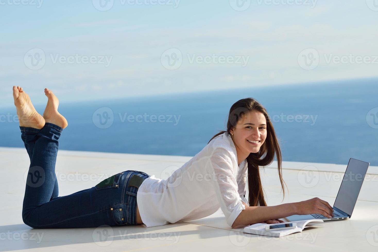 jeune femme détendue à la maison travaillant sur un ordinateur portable photo