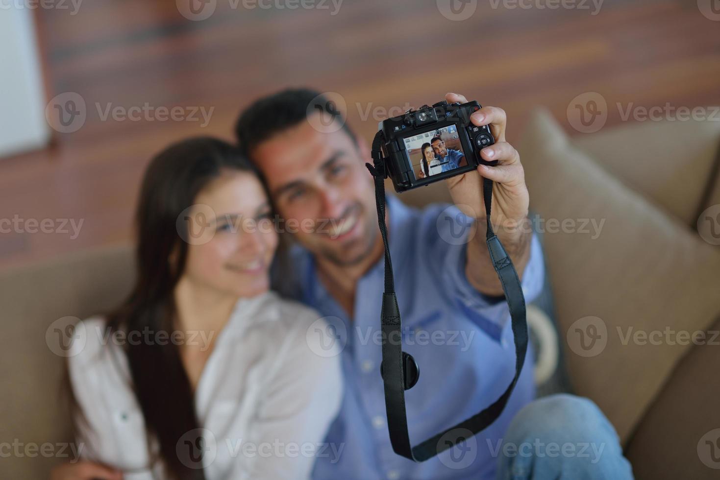 couple jouant avec un appareil photo numérique à la maison