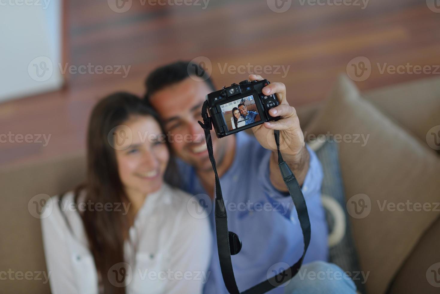 couple jouant avec un appareil photo numérique à la maison