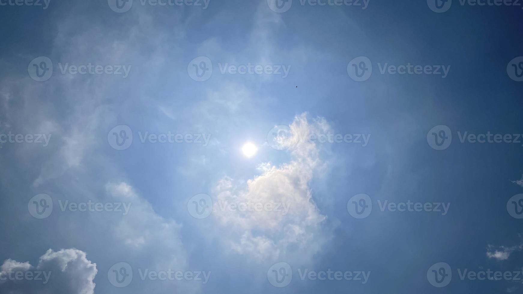 des nuages blancs célestes sur le ciel bleu avec le soleil sont apparus photo