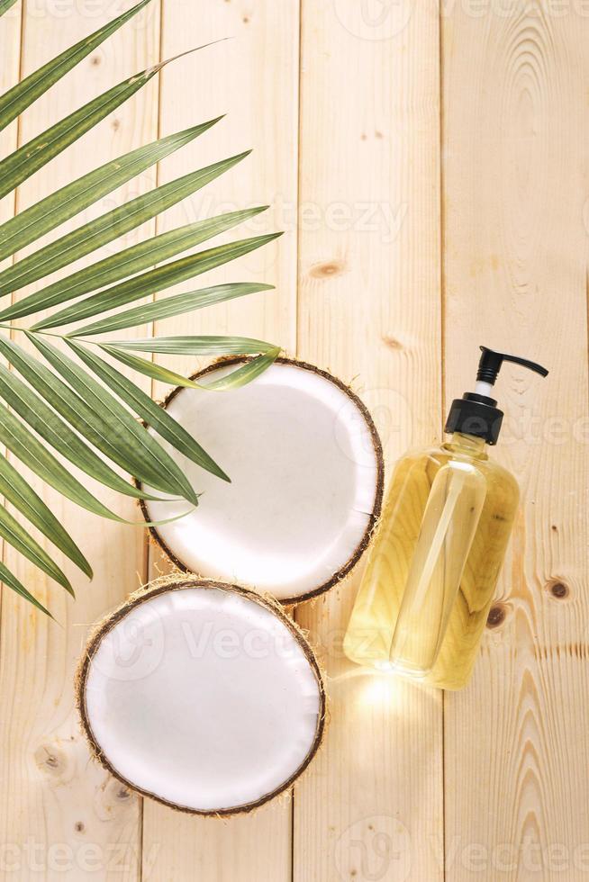 noix de coco craquelée et une bouteille d'huile sur la table - spa, soins de la peau, soins capillaires et concept de relaxation photo