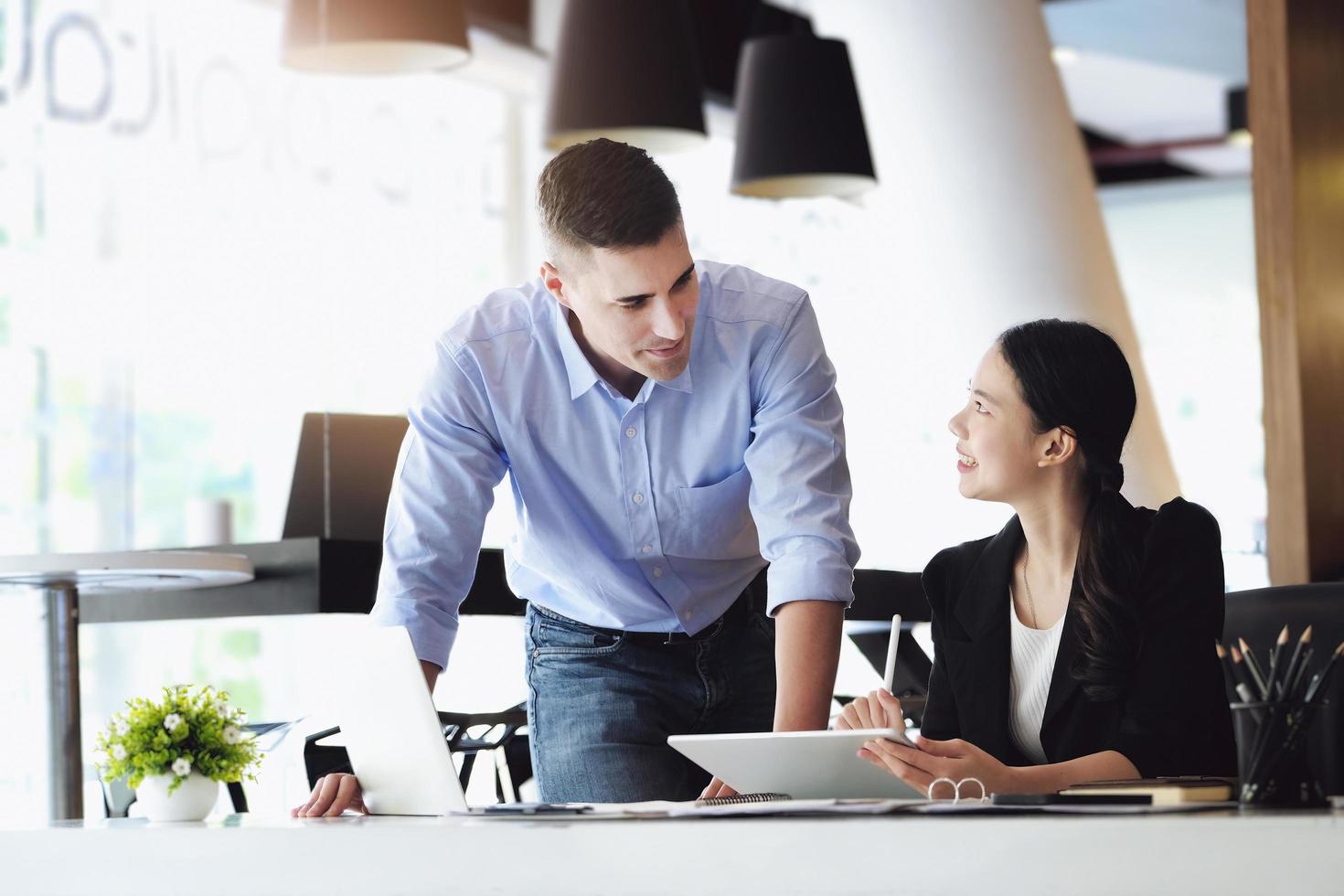 le responsable marketing masculin a exprimé sa satisfaction de vendre les produits de l'entreprise. où les membres de l'équipe affichent les ventes à partir de l'écran de leur ipad. photo