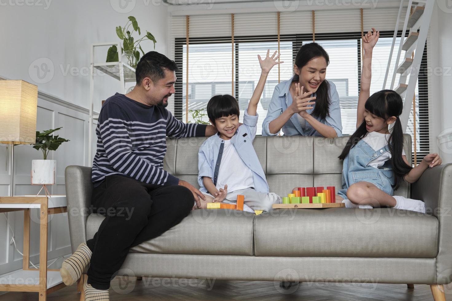 Happy Asian Lovely Thai Family Care, papa, maman et petits enfants s'amusent à jouer avec des blocs de jouets colorés ensemble sur un canapé dans un salon blanc, un week-end de loisirs et un style de vie de bien-être domestique. photo