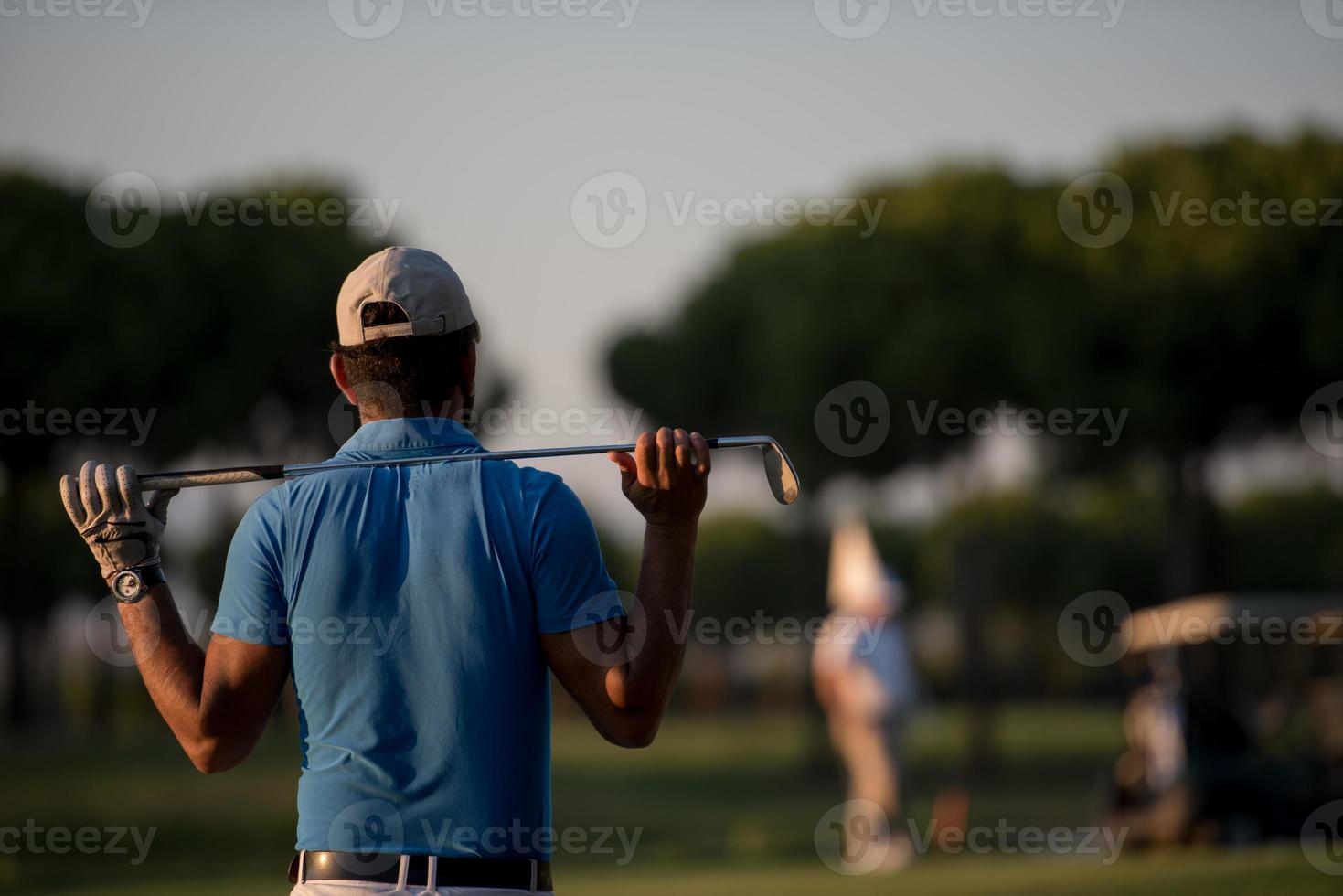 golfeur de dos au cours à la recherche d'un trou à distance photo