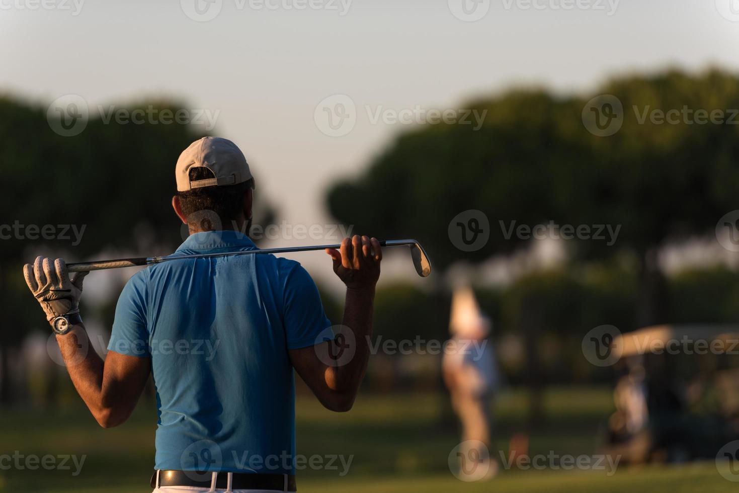 golfeur de dos au cours à la recherche d'un trou à distance photo