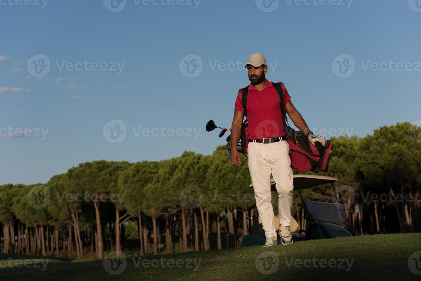 golfeur marchant et portant un sac de golf photo