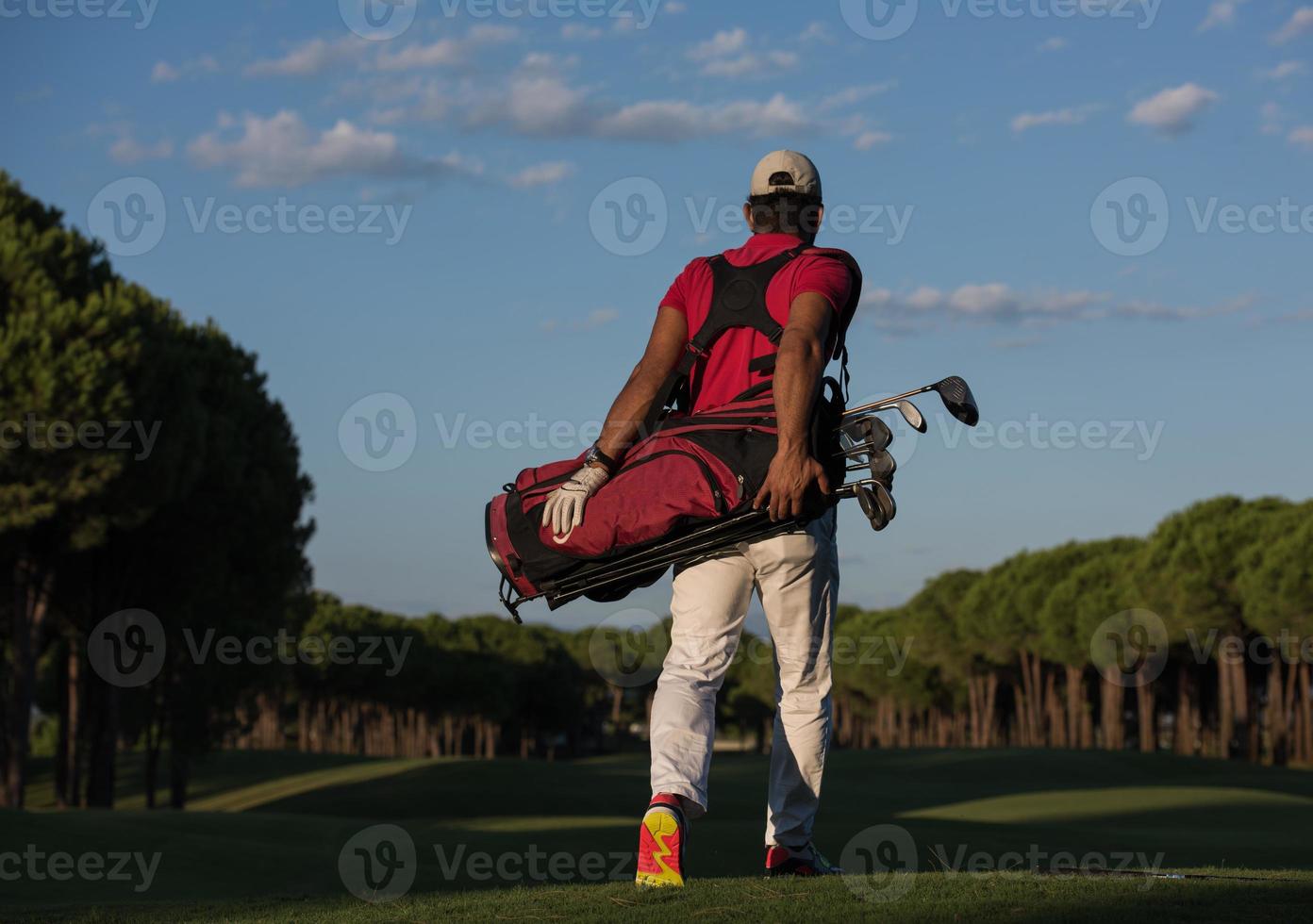 golfeur marchant et portant un sac de golf photo