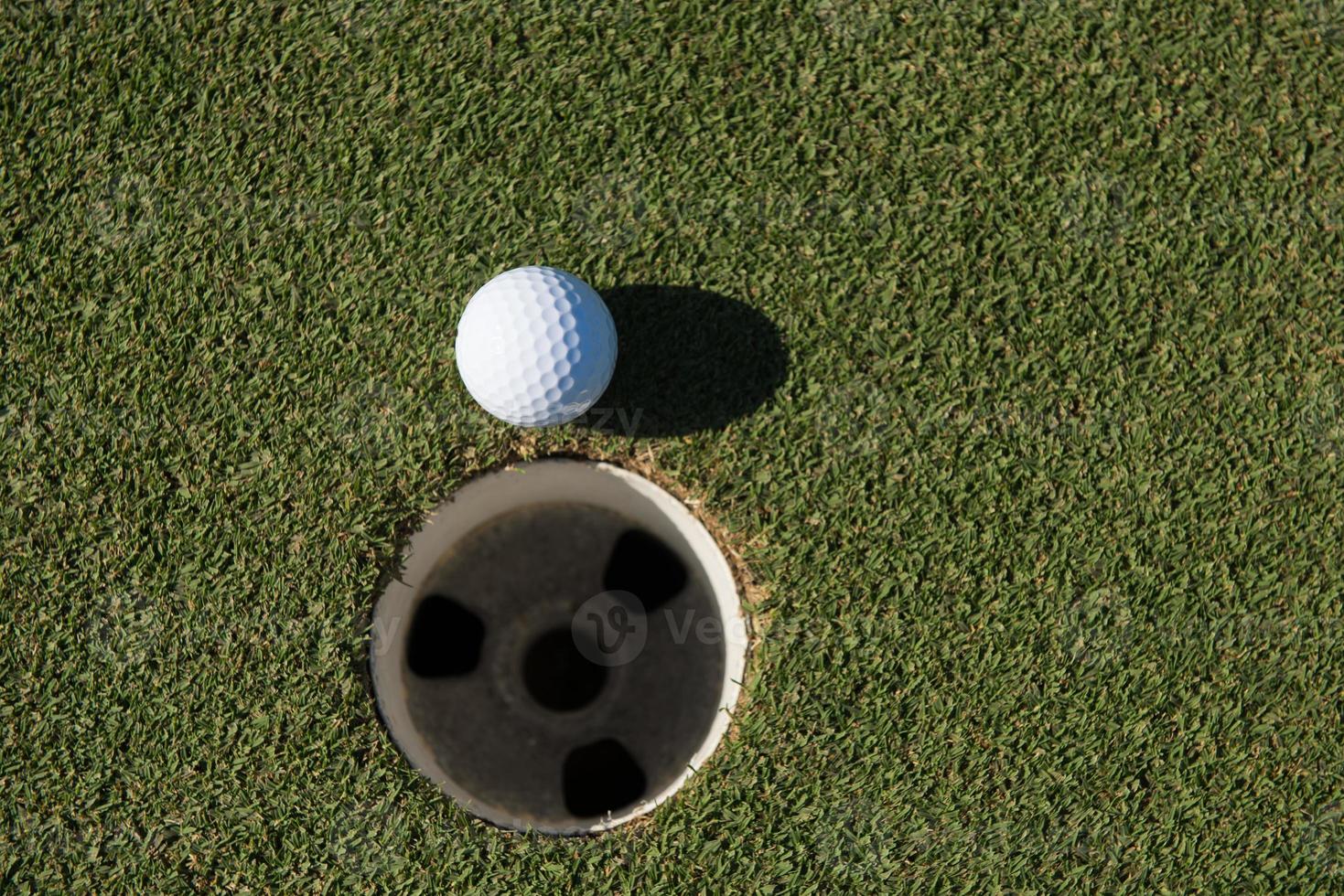 vue de dessus de la balle de golf dans le trou photo