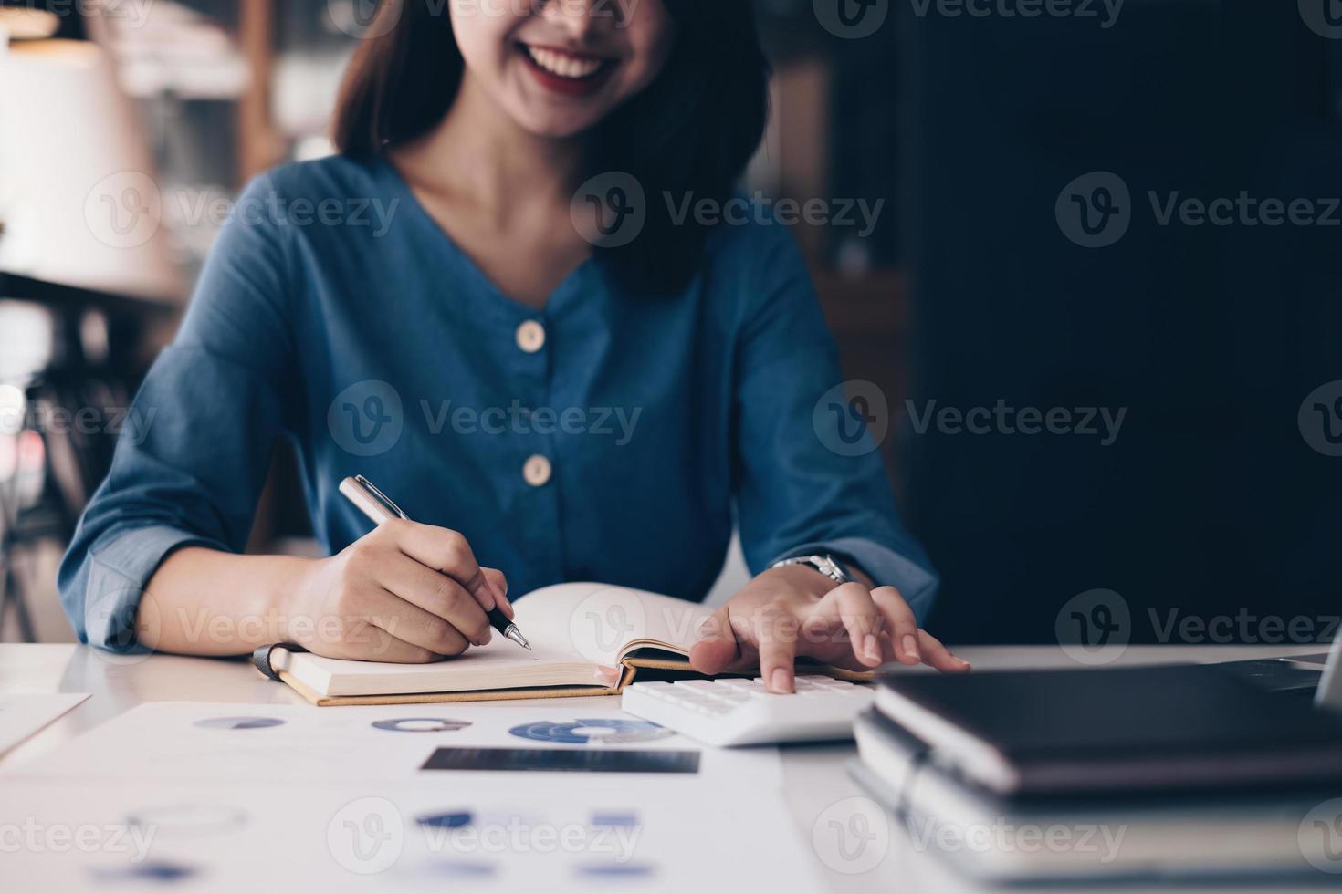 femme d'affaires asiatique ou mains de comptable tenant un stylo écrit dans un cahier avec paperasse, compte, audit et concept d'épargne. photo