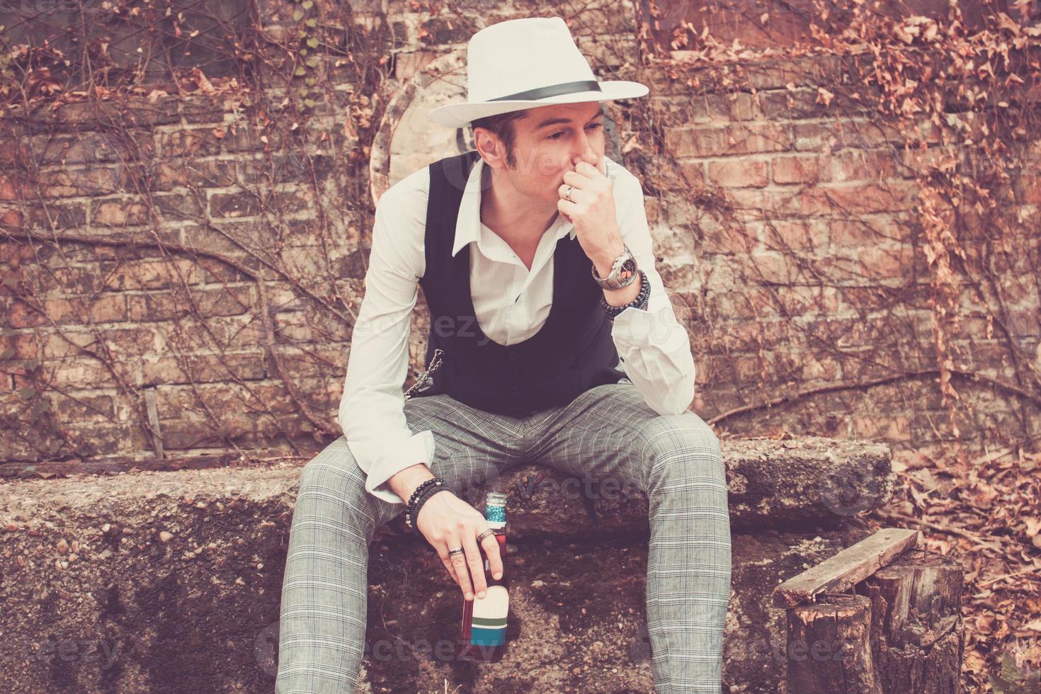 homme pensif avec une bouteille de bière pensant à l'extérieur. photo