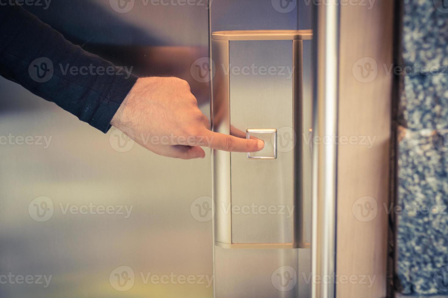 gros plan d'un homme appuyant sur le bouton de l'ascenseur. photo