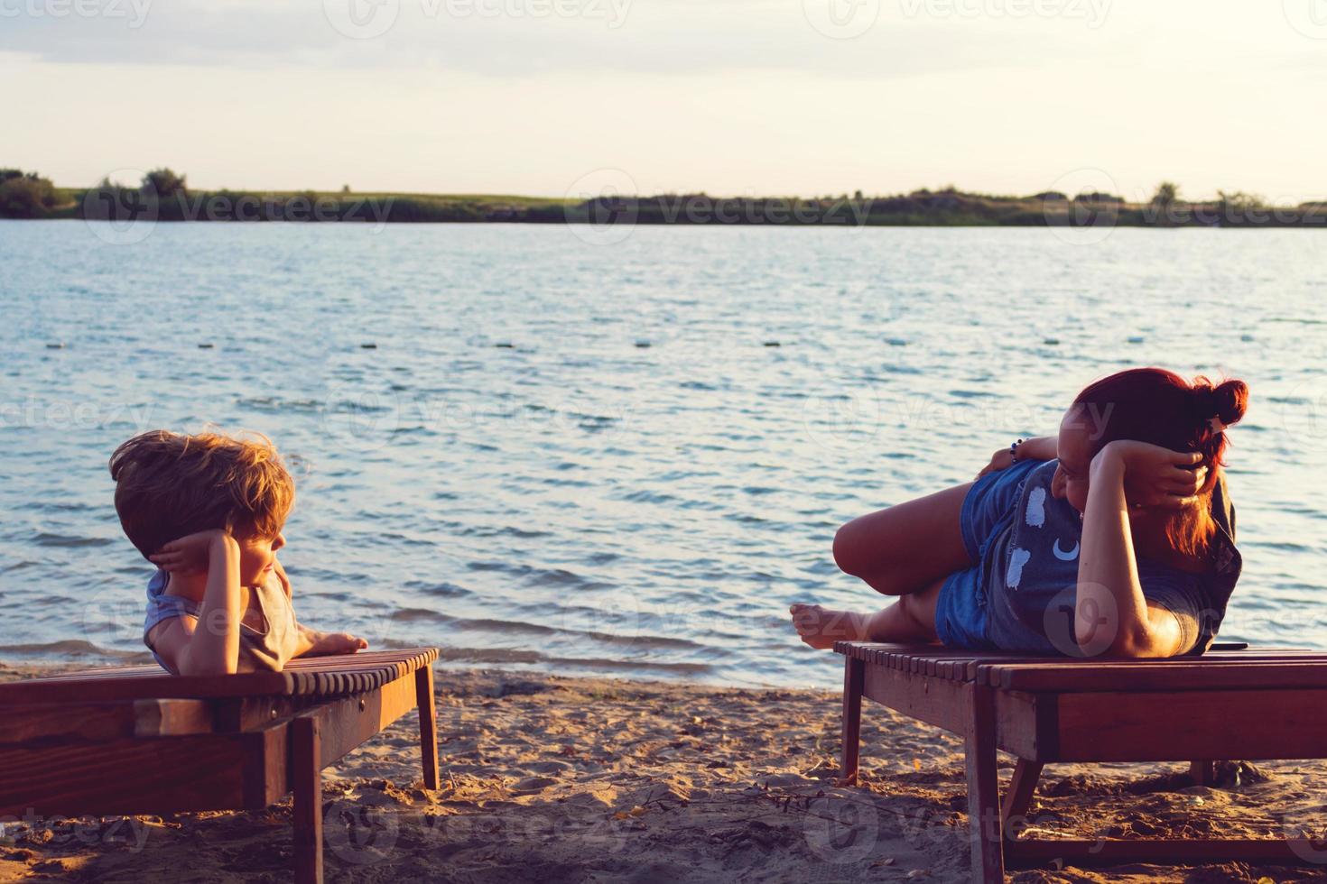 heureuse mère et fils se reposant sur la plage pendant les vacances d'été. photo