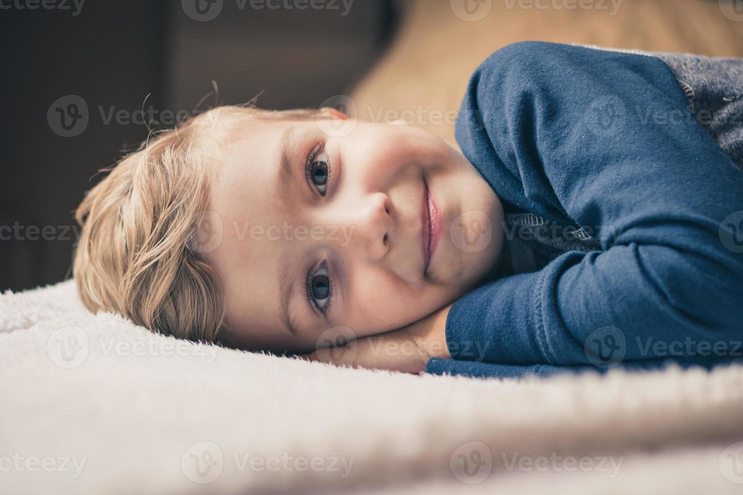 mignon petit garçon allongé sur le lit. photo