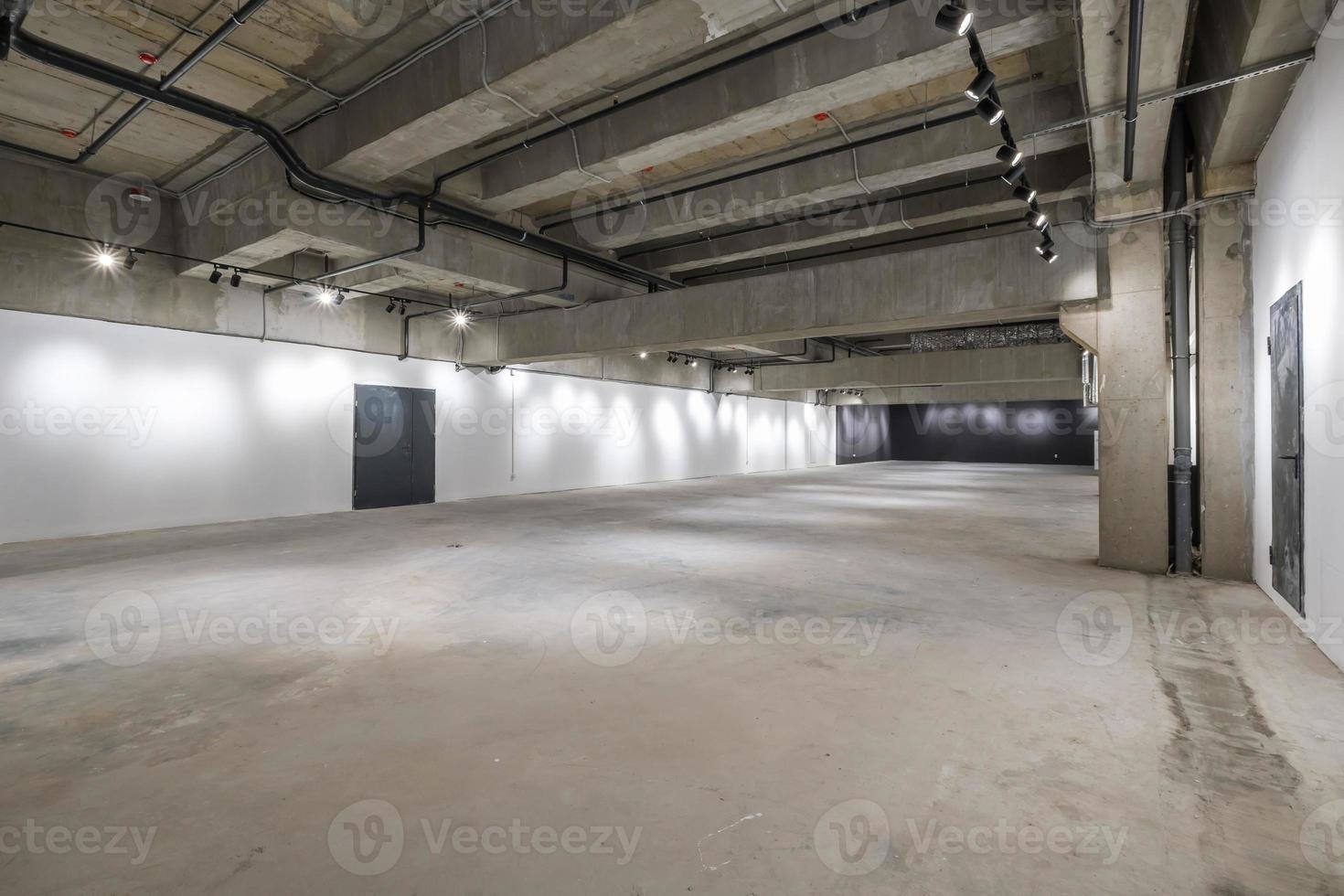 intérieur vide d'une grande pièce en béton comme entrepôt ou hangar avec projecteurs photo