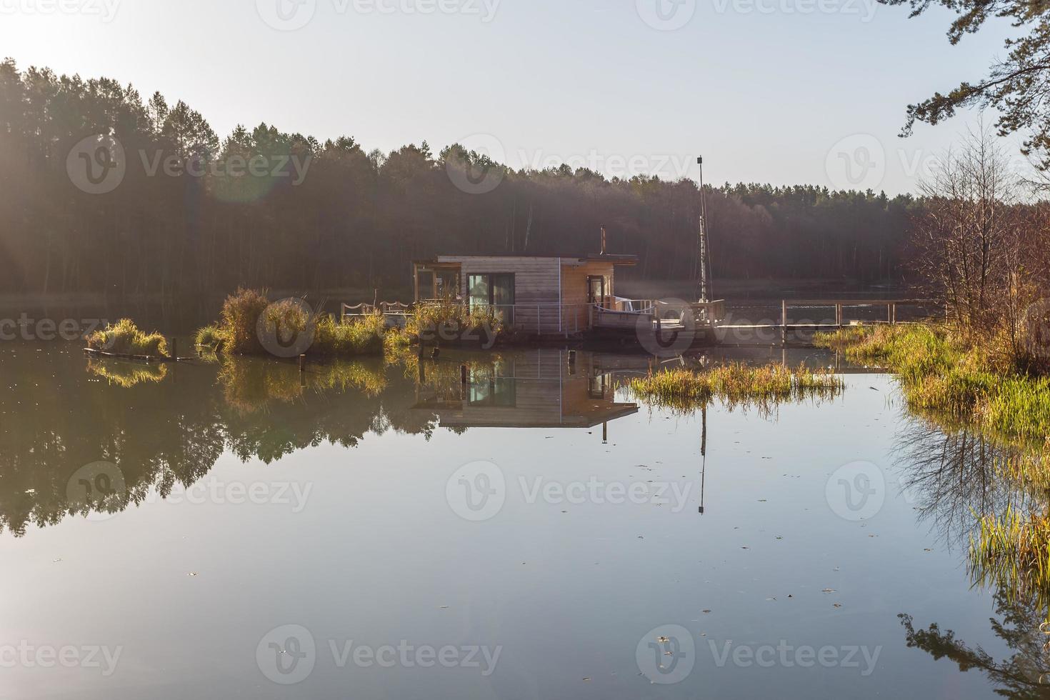 maison de débarcadère sur une jetée en bois dans l'eau en forêt en soirée photo