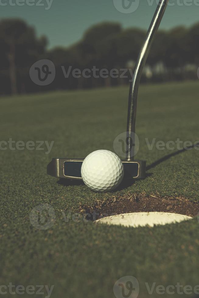 frapper la balle de golf dans le trou photo