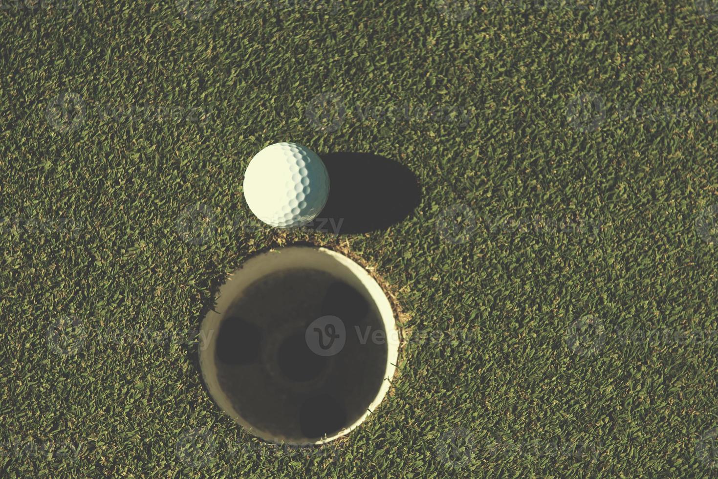 vue de dessus de la balle de golf dans le trou photo