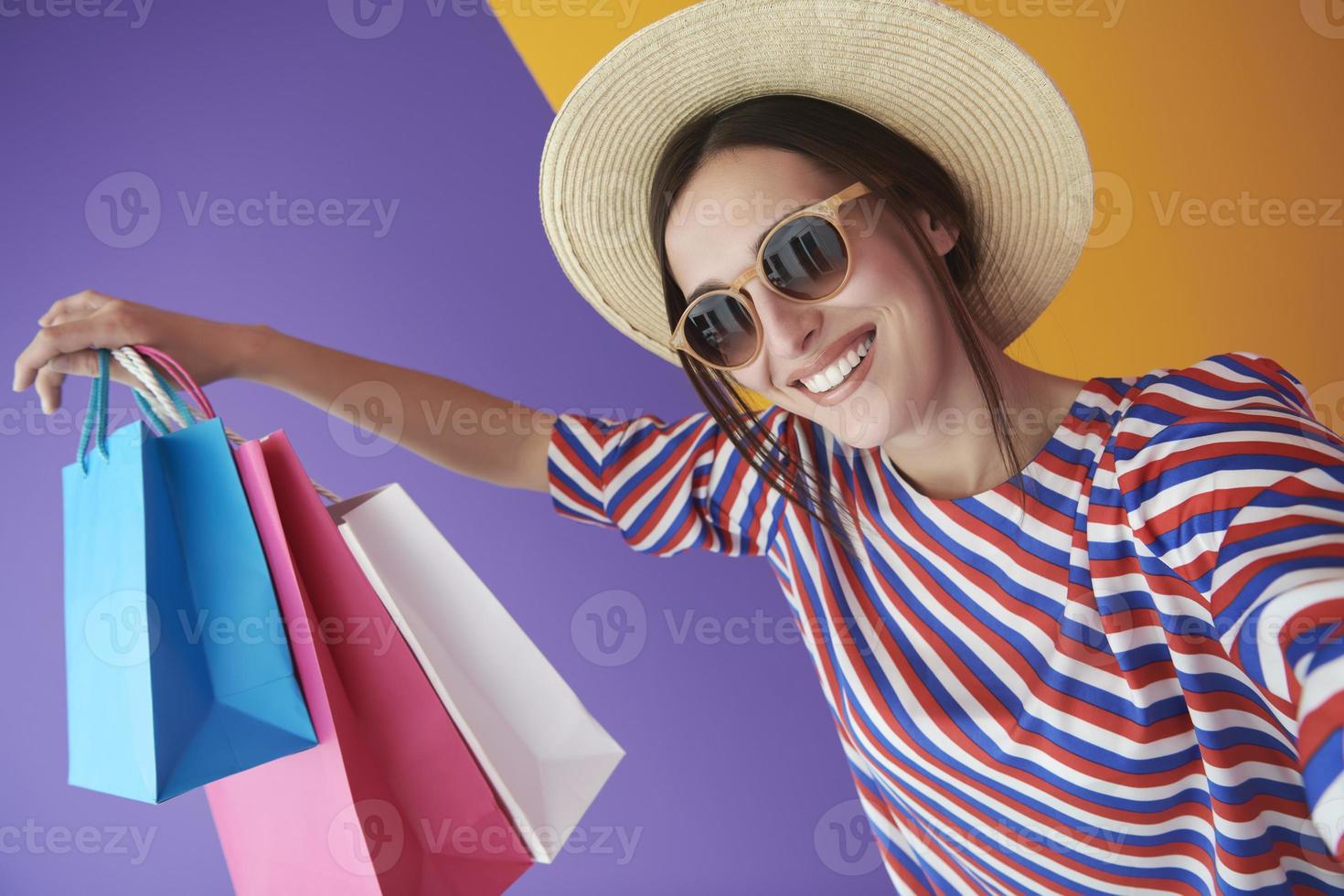 jeune femme avec des sacs à provisions sur fond coloré photo