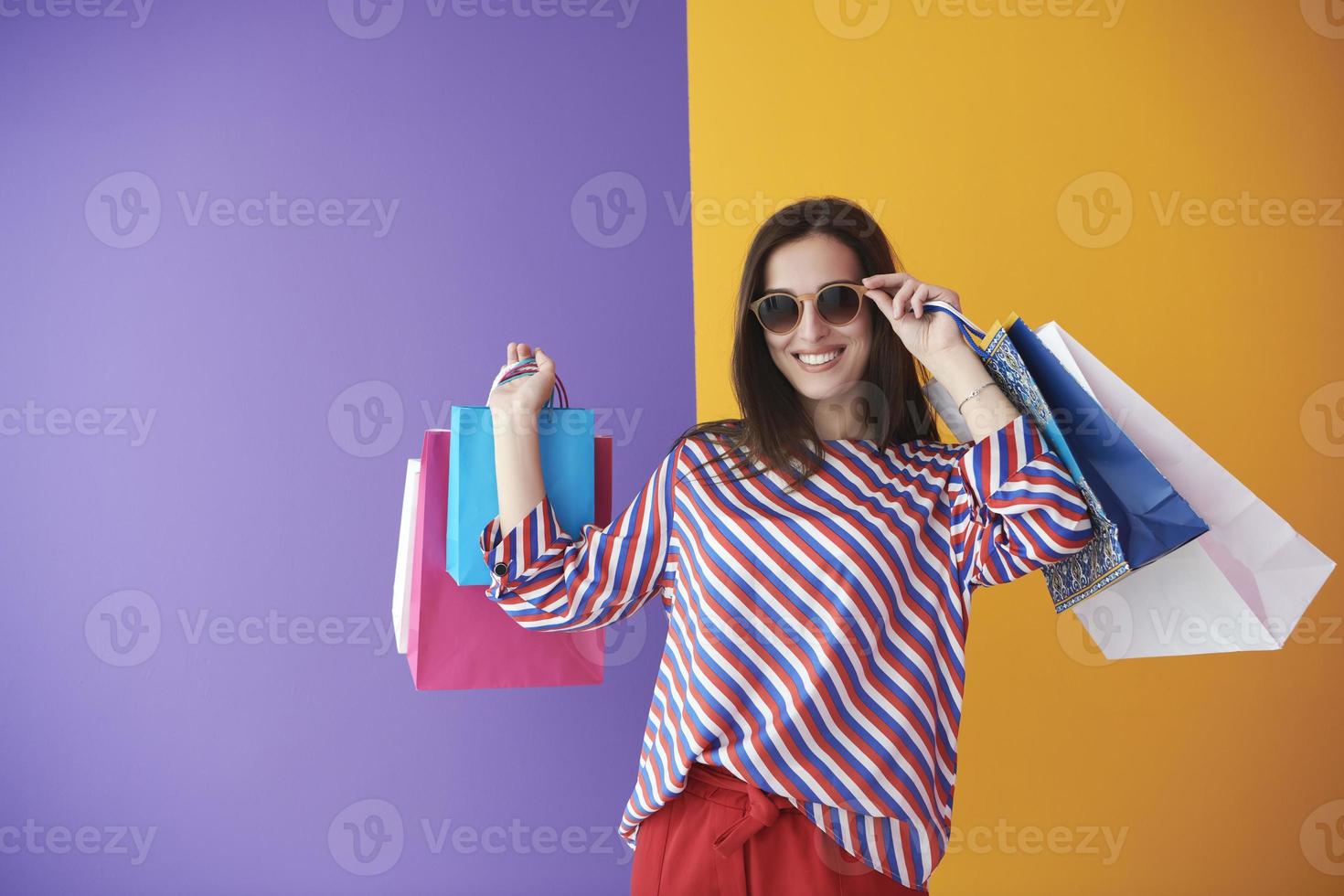 jeune femme avec des sacs à provisions sur fond coloré photo