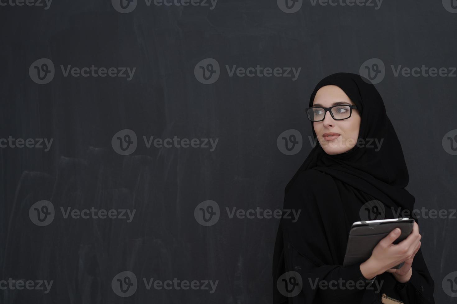 jeune femme d'affaires arabe en vêtements traditionnels ou abaya tenant une tablette photo