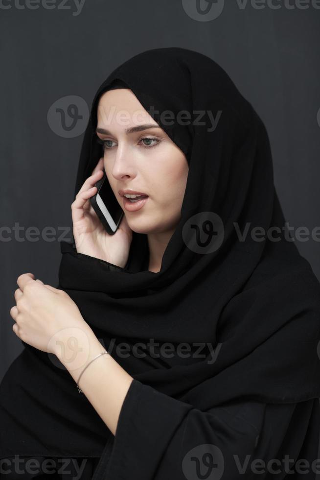 jeune femme d'affaires musulmane en vêtements traditionnels ou abaya parlant sur le smartphone photo