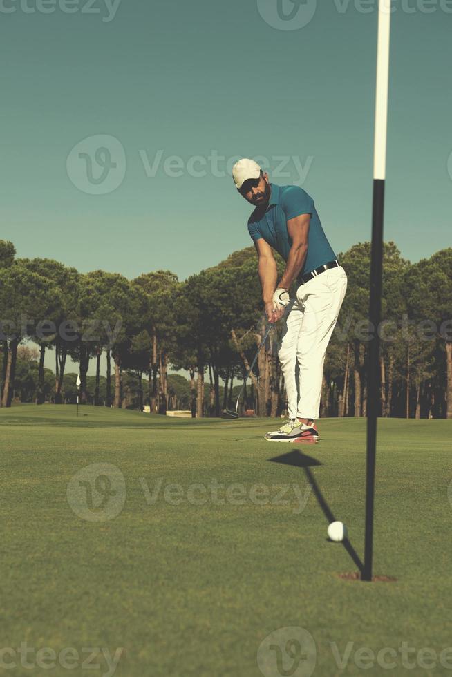 joueur de golf frappant le coup à la journée ensoleillée photo