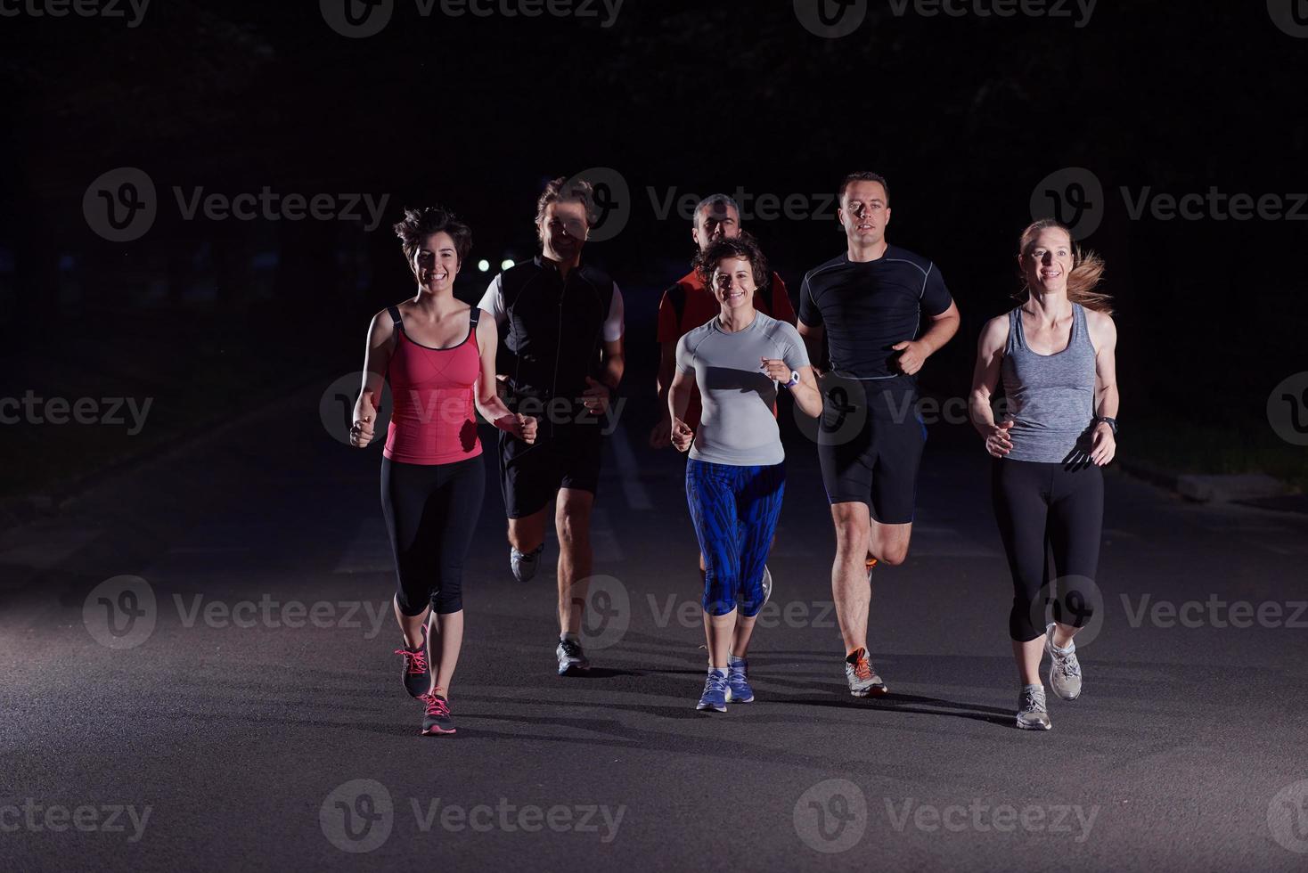 groupe de personnes faisant du jogging la nuit photo