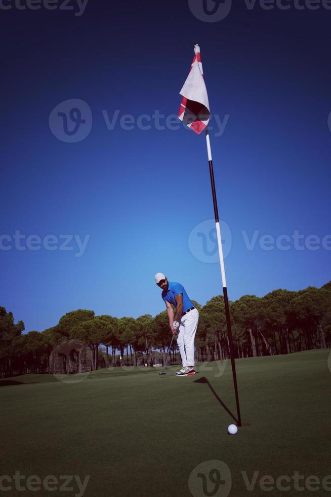 joueur de golf frappant le coup à la journée ensoleillée photo