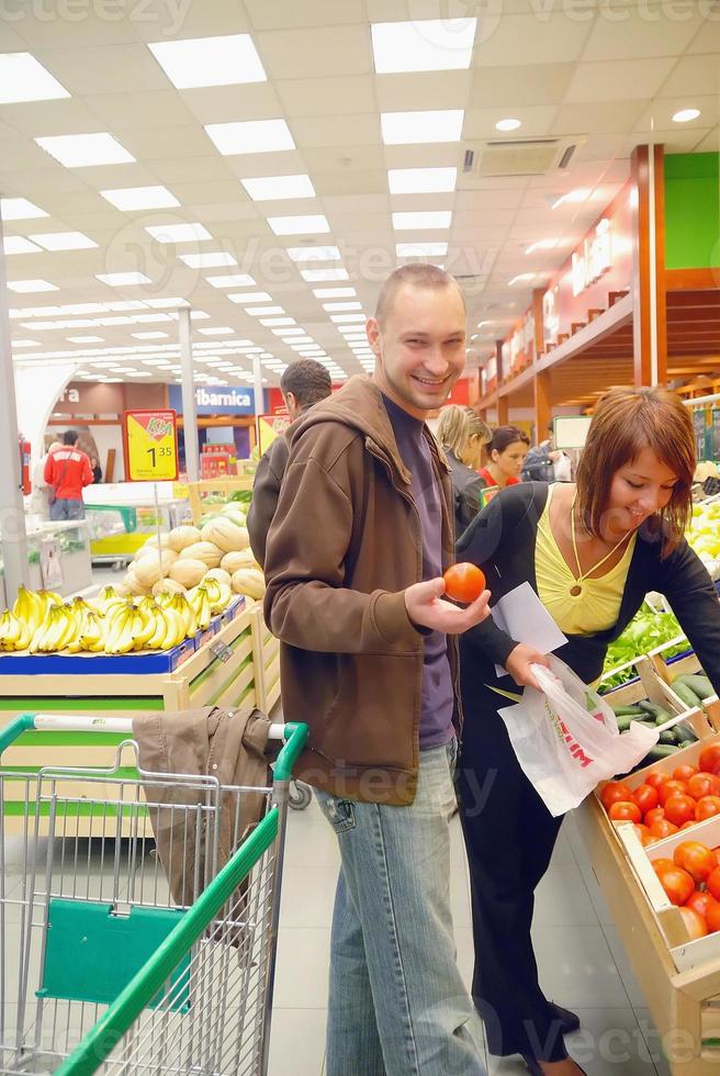 couple heureux achetant des fruits dans un hypermarché photo