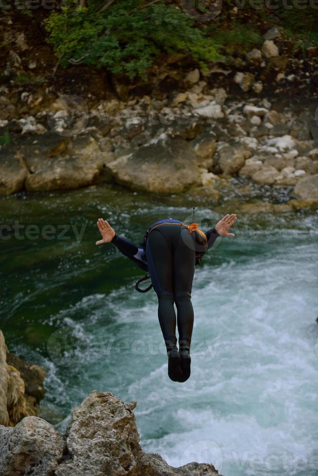 homme sautant dans une rivière sauvage photo